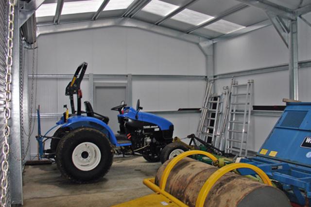 A blue tractor and ladders inside a building