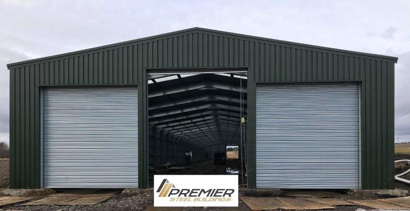 Front view of a large olive green steel building with a central open bay flanked by two closed silver roller shutter doors, featuring the Premier Steel Buildings logo.